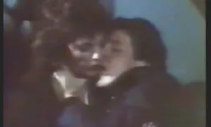 Một sinh viên lớn đùi mình quần màu xanh, ngồi trên một da đen ngâm trong phim sẽ hoc sinh nhat ban dầu, làm gián đoạn để thổi kèn.